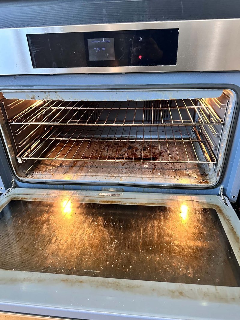 Oven interior and open door before cleaning