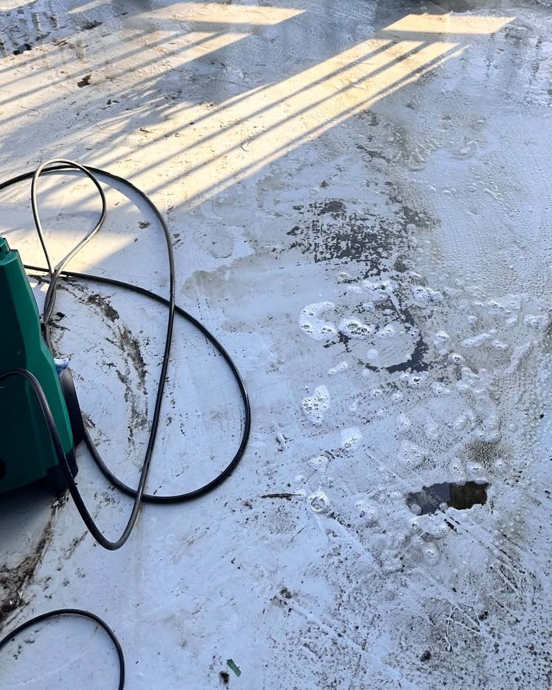 Balcony surface with cleaning solution and equipment while cleaning is underway
